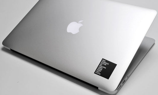 Der schwarze KANNSTEMACHEN Sticker auf einem MacBook Air